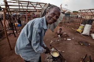 Un refugiado prepara su comida en el campo de refugiados de Cacanda. Los equipos de MSF colaboraron asimismo en el establecimiento inicial de provisión de agua y saneamiento en el campo.©Bruno Fonseca