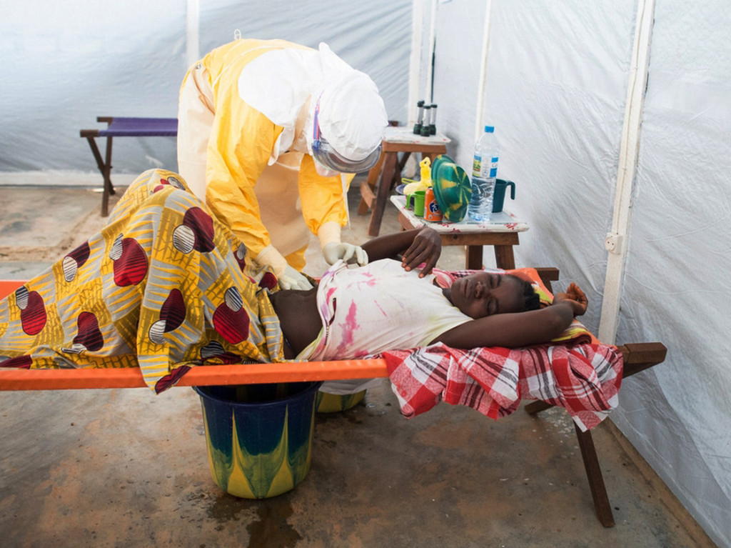 Médico atendiendo a una paciente con ébola en Guinea. Fuente: NPR.