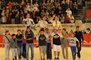 FOTO: JOËL BURAVAND ALTERNATIVA TRIUNFAL. Andrés Roca Rey (der.) en hombros, junto a su padrino Enrique Ponce y el francés Juan Bautista, al culminar una corrida memorable en Nimes, en la que el peruano, a pesar de lidiar un lote poco propicio, logró estar a la altura del compromiso.