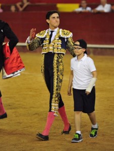 Andrés Roca Rey dando la vuelta al ruedo en Valencia con adrián un niño con una rara enfermedad genética que le causa hidrocefalia y deformaciones en las manos, pero que encuentra inspiración en la tauromaquia para superar su enfermedad.