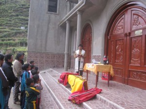 Niños peruanos haciendo que el párroco del pueblo bendiga sus trastos.