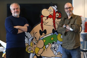 Author Jean-Yves Ferri and illustrator Didier Conrad pose next to cardboard cut-out of Obelix and Asterix in Vanves, Southern Paris